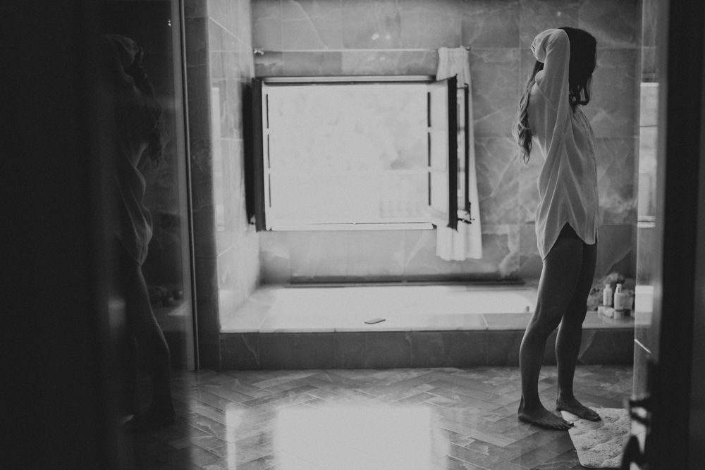 A silhouette standing in an empty hallway with natural light streaming in.