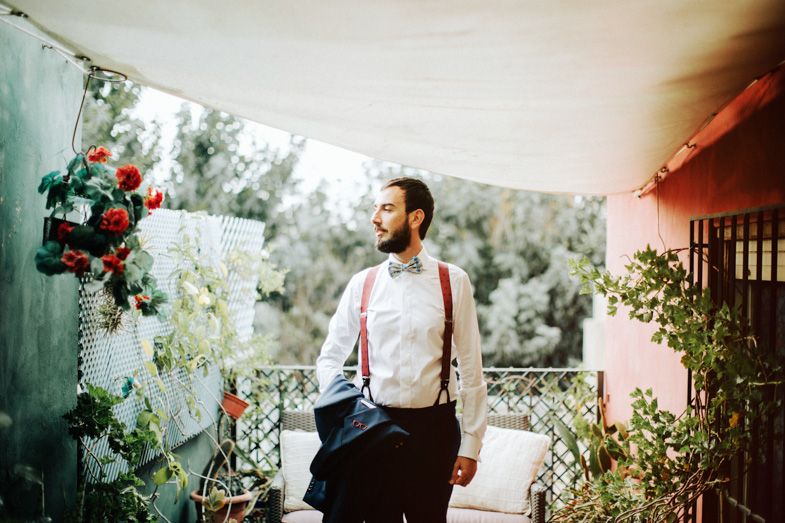 Stylish formal wear against a backdrop of pink walls and climbing roses on a patio.