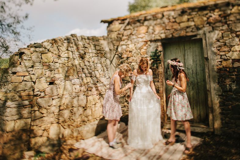 Wedding party gathered by an old stone wall with vintage green door.