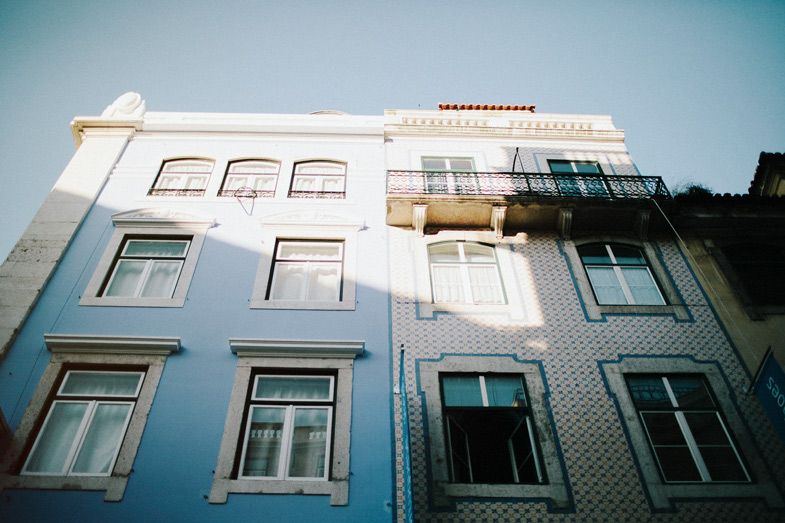 White and blue tiled building facade with symmetrical windows in Portuguese architectural style.