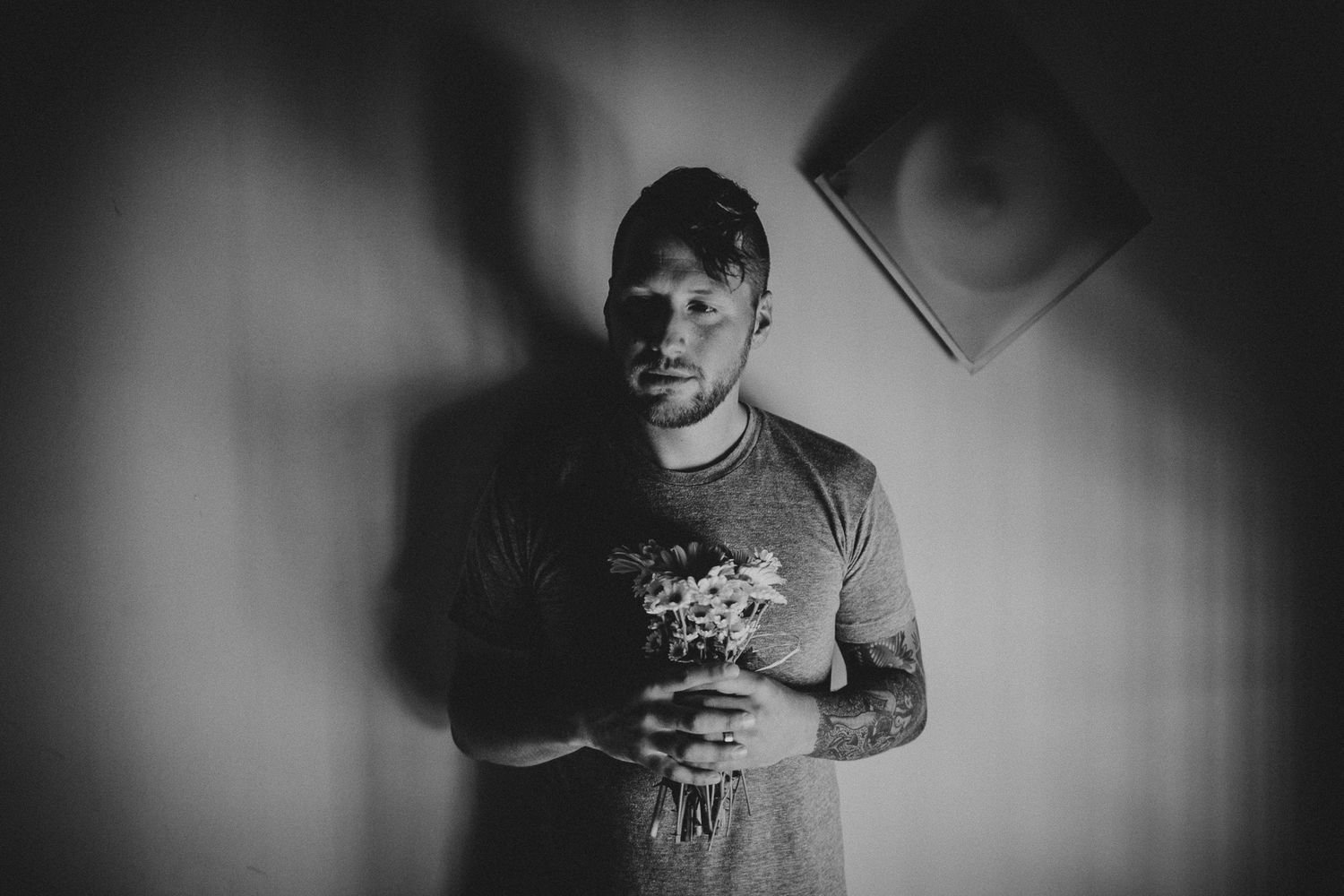 Moody black and white portrait with dramatic shadows and vignette effect.