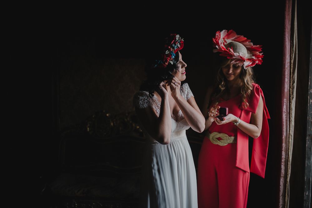 Two figures in contrasting white and red outfits share a moment in dramatic lighting.