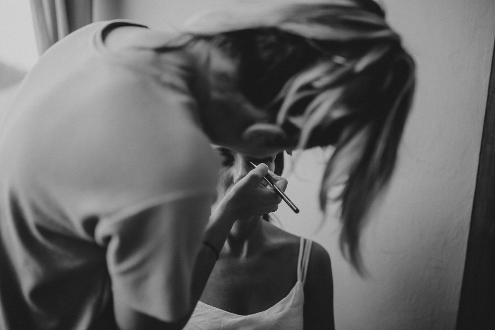 Black and white close-up photo of someone applying makeup.