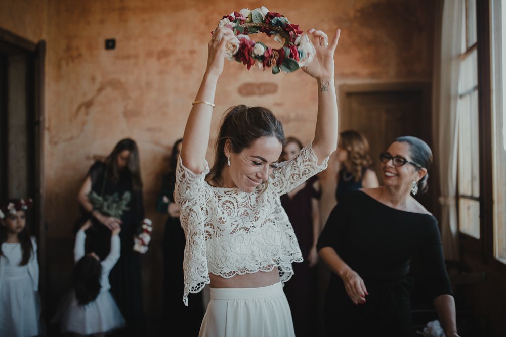 Someone celebrating with a floral crown in a rustic indoor setting.