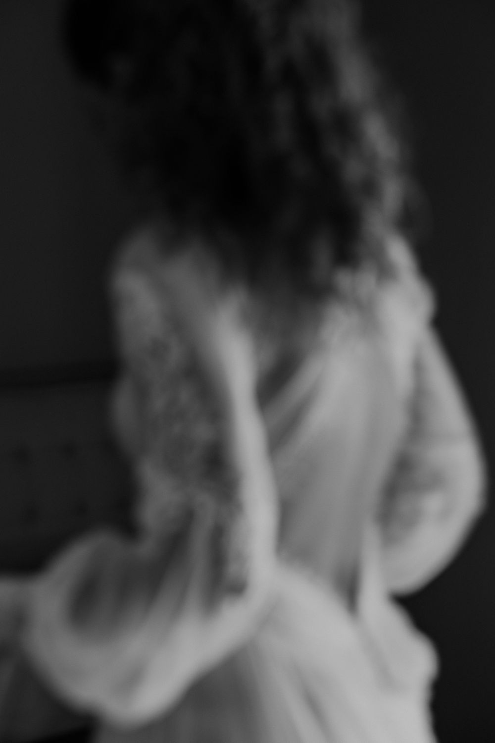 Artistic black and white motion sequence of flowing fabric in darkness.