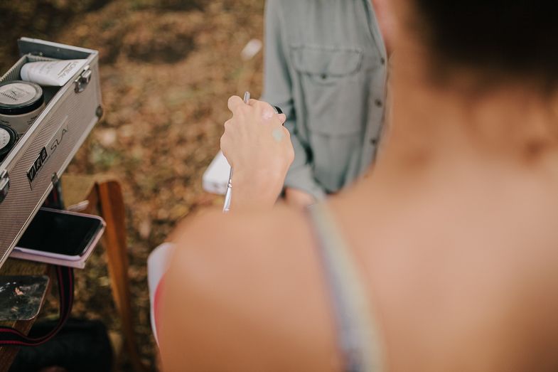 Detail shot of someone preparing food or drinks at an outdoor table.