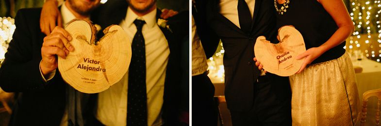 Wedding guests hold decorative wooden signs during the evening celebration.