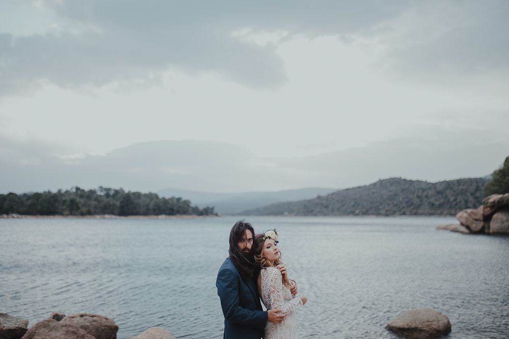A romantic lakeside moment captured against a backdrop of misty mountains and calm waters.