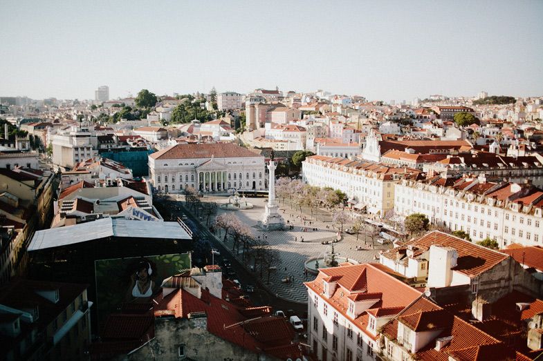 Aerial view of Lisbon's historic city center with red-tiled roofs and main square.