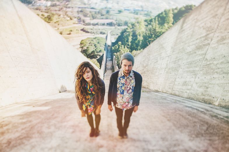 Couple walking down steep concrete path between hills.