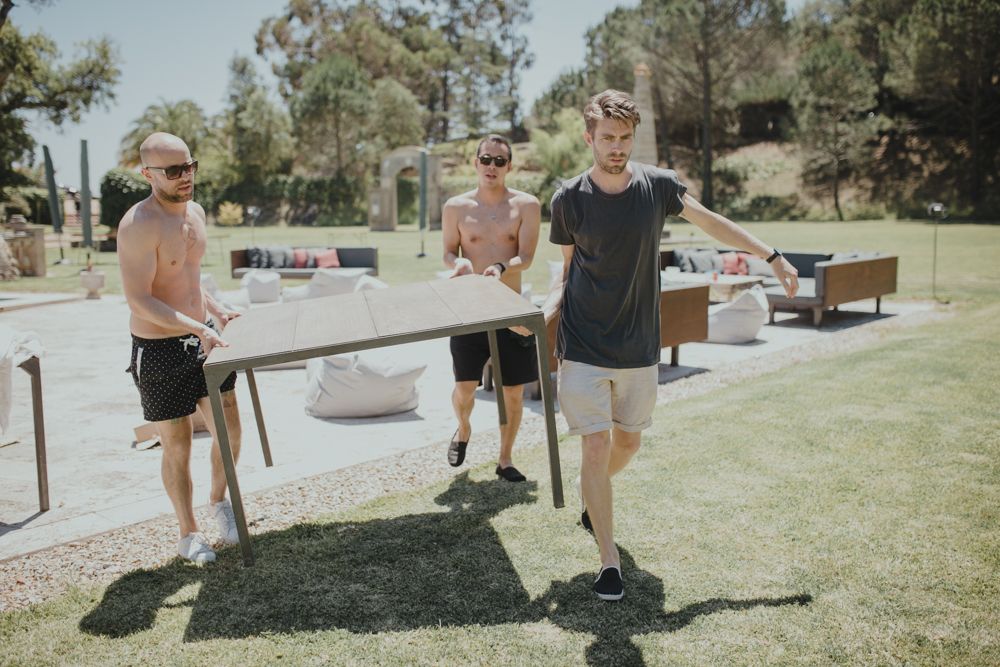 Group chatting at an outdoor party with casual summer attire.