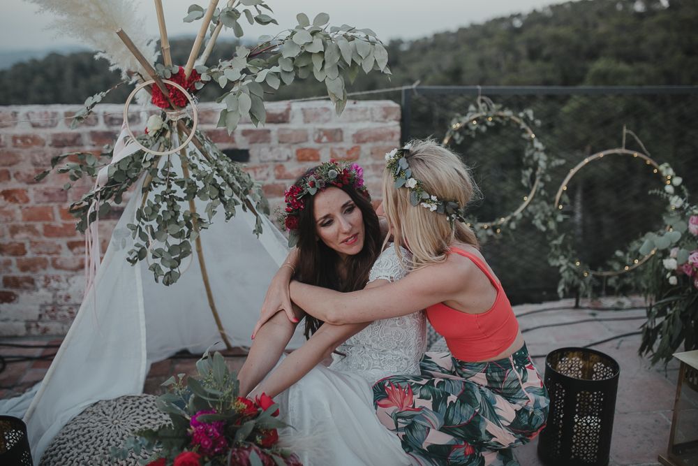 Beautiful wedding celebration on a rooftop terrace decorated with floral arrangements and greenery.