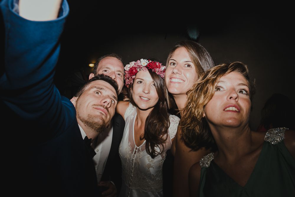 Group taking festive selfie together at nighttime celebration.