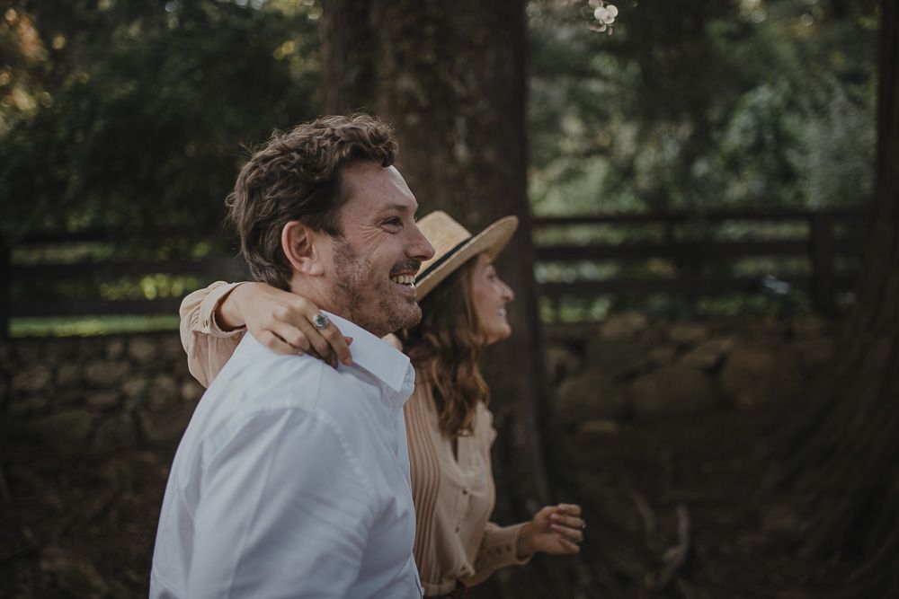 A joyful embrace captured in natural lighting against rustic scenery.