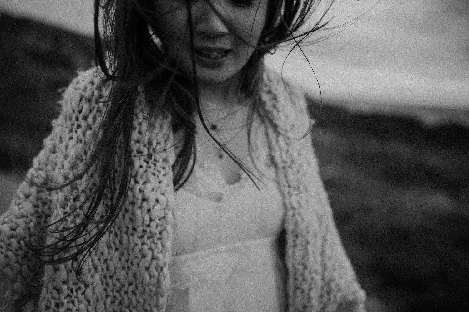 Black and white portrait showing movement and joy in a windswept moment.