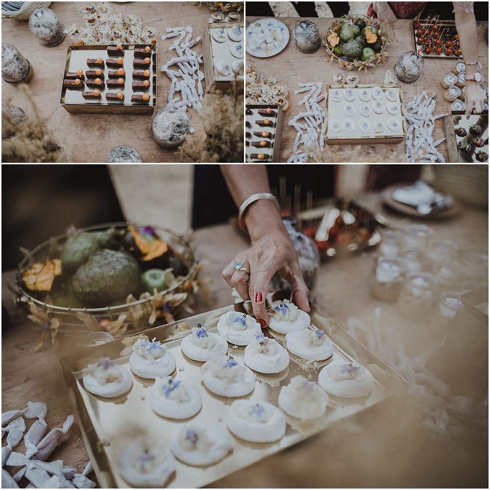 Overhead view of an elegant dessert table with decorative pastries and treats being arranged for a special occasion.