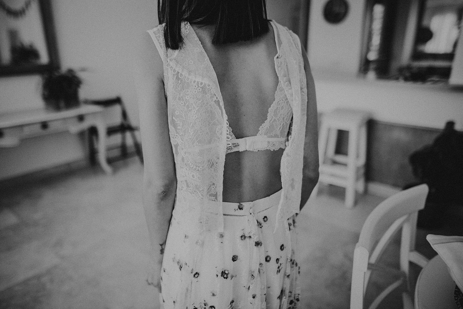 Black and white photograph showing details of a delicate lace dress design.