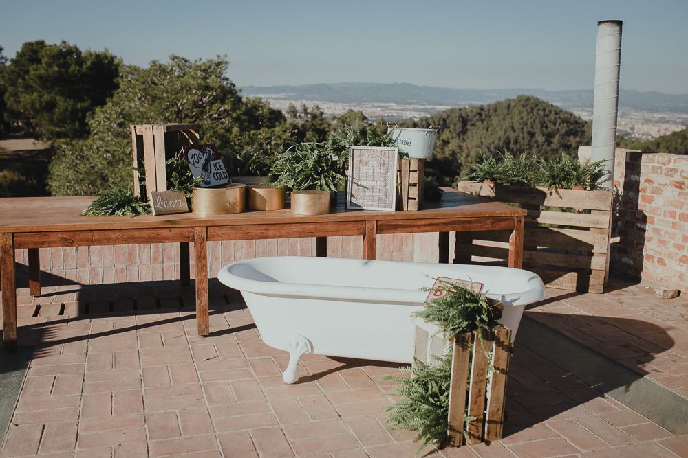 Outdoor setup with wooden tables and potted plants against a mountain backdrop.