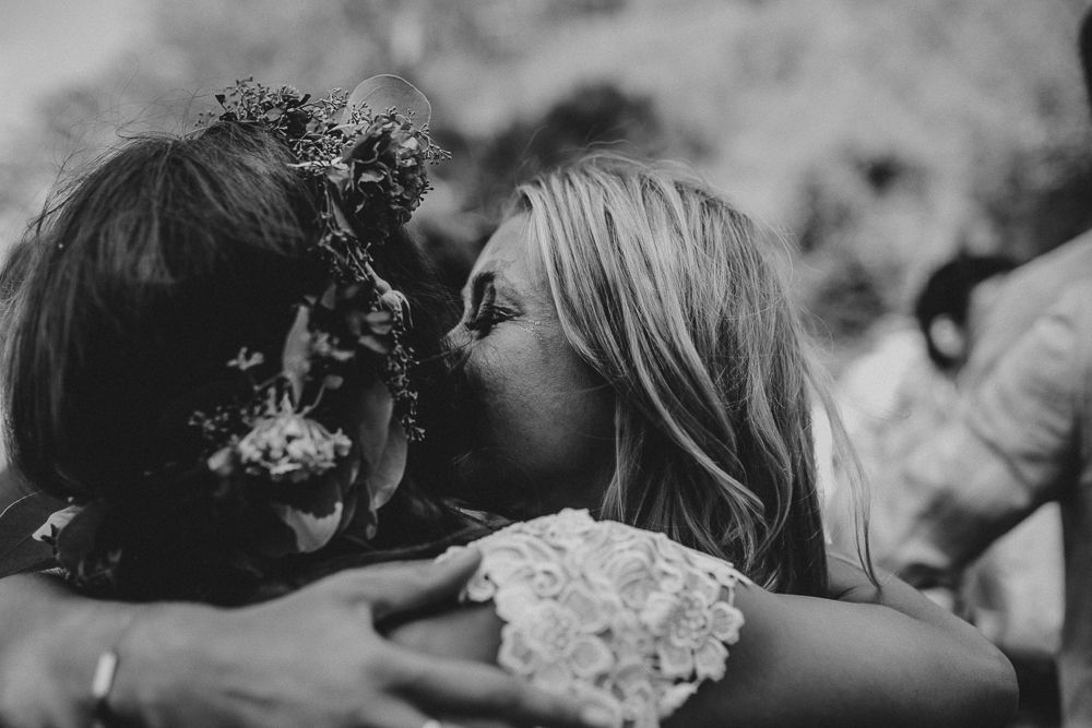 An intimate black and white wedding moment with a flower crown and lace dress.