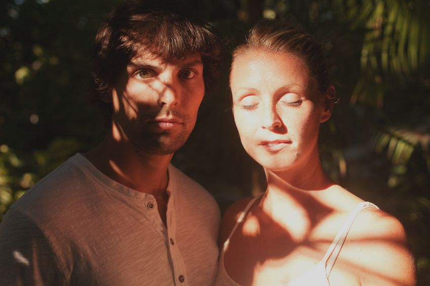 A sun-drenched portrait of a couple with dramatic natural lighting.