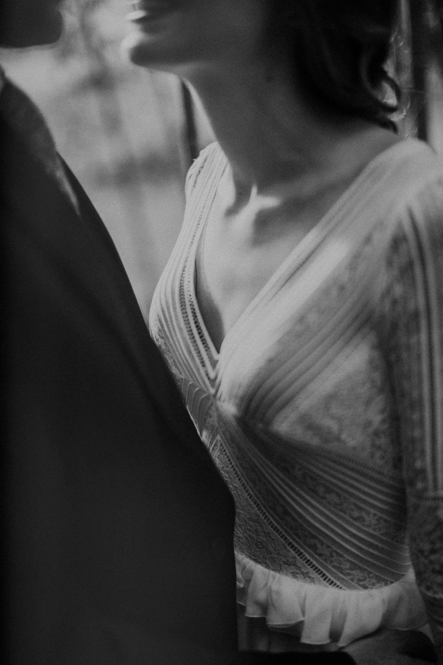 Artistic black and white close-up of a bride's elegant pleated wedding dress bodice.