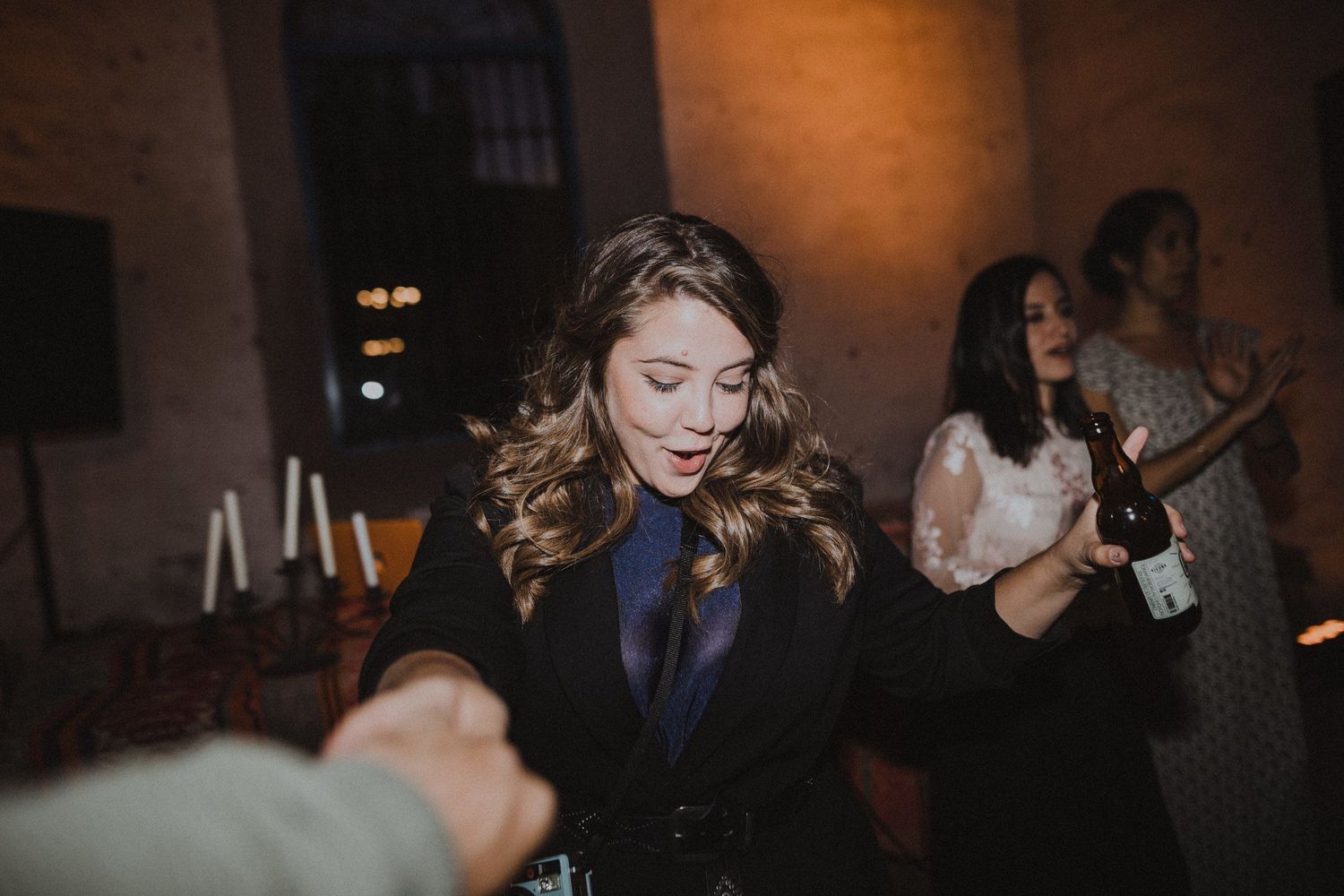 Person dances with eyes closed in dark formal attire at indoor event.
