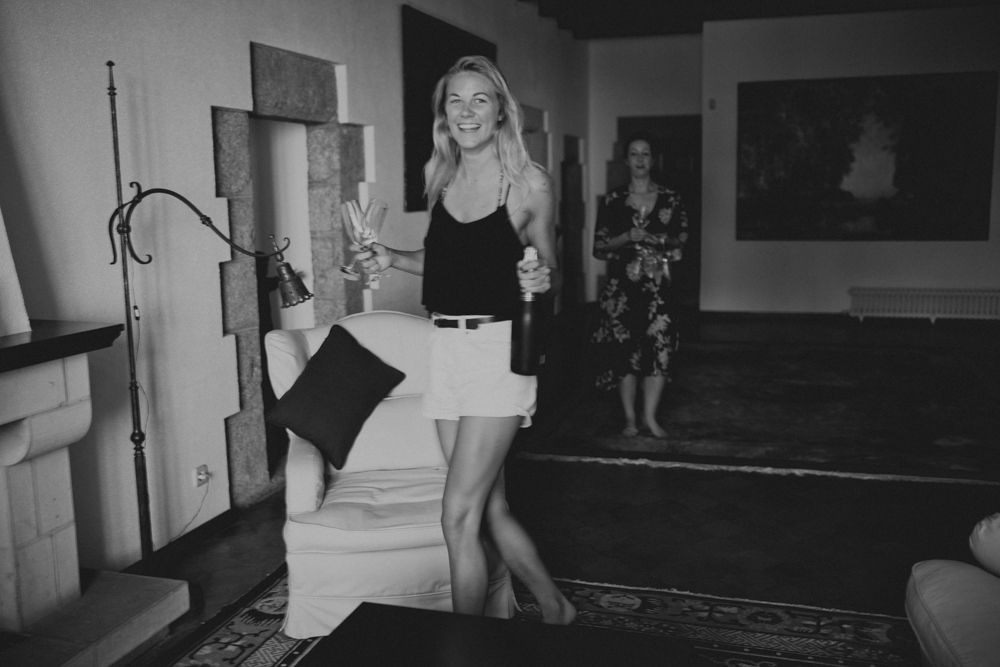 Black and white photo of person standing by vintage furniture.