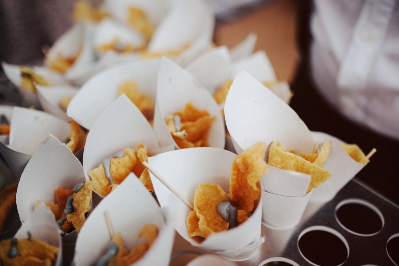 Paper cones filled with golden fried appetizers arranged closely together.