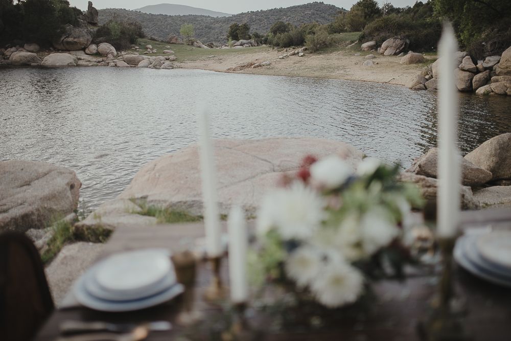 Lakeside dining table with mountain views and white floral decorations.