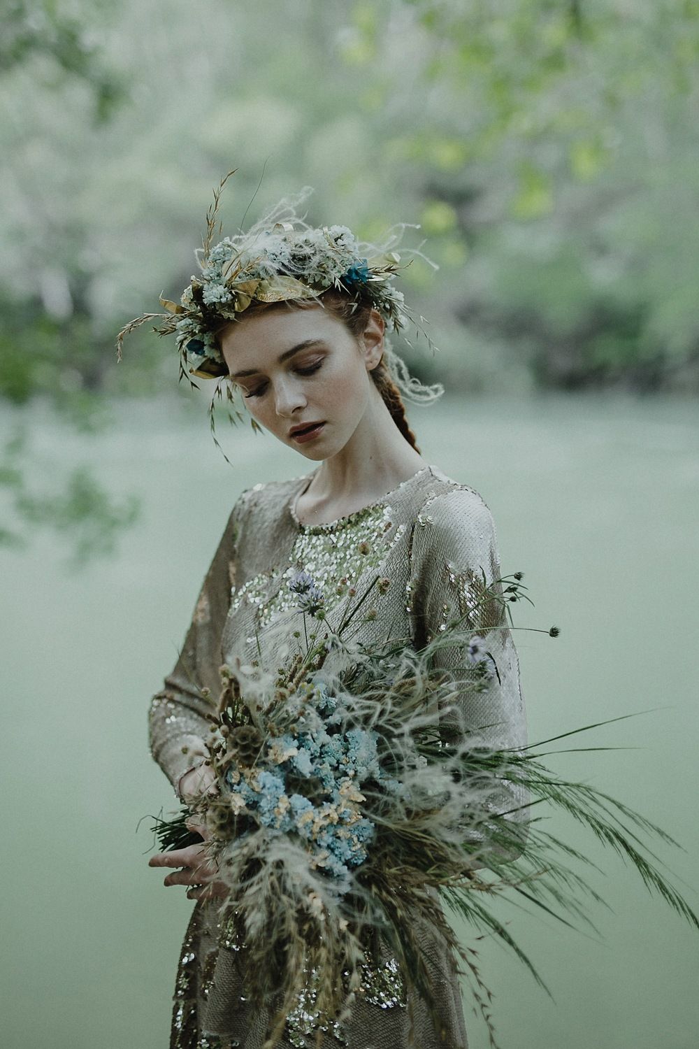 Dreamy portrait with botanical crown and textured dress holding dried flowers.