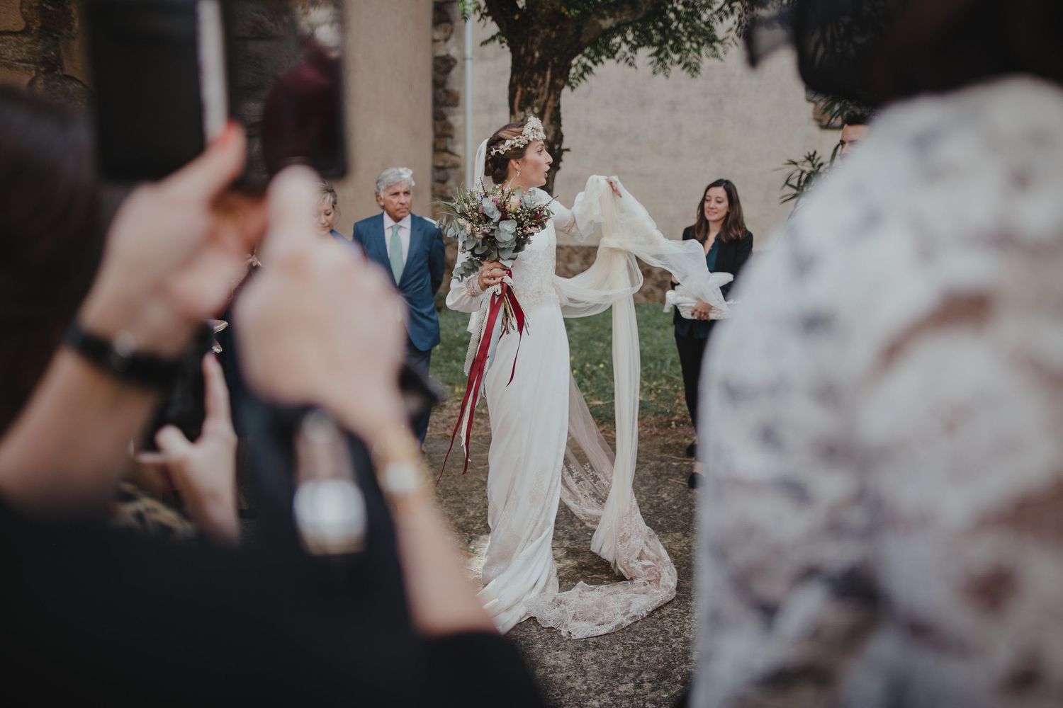 Wedding guests capture photos of dancing celebration outdoors.