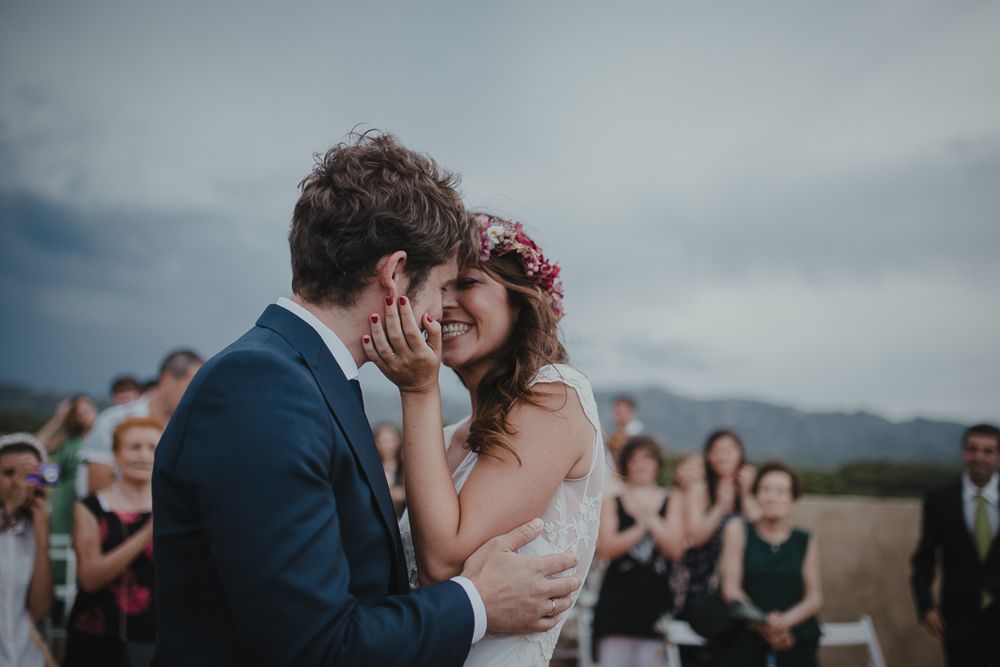 Newlyweds share an intimate moment during their outdoor mountain wedding ceremony.