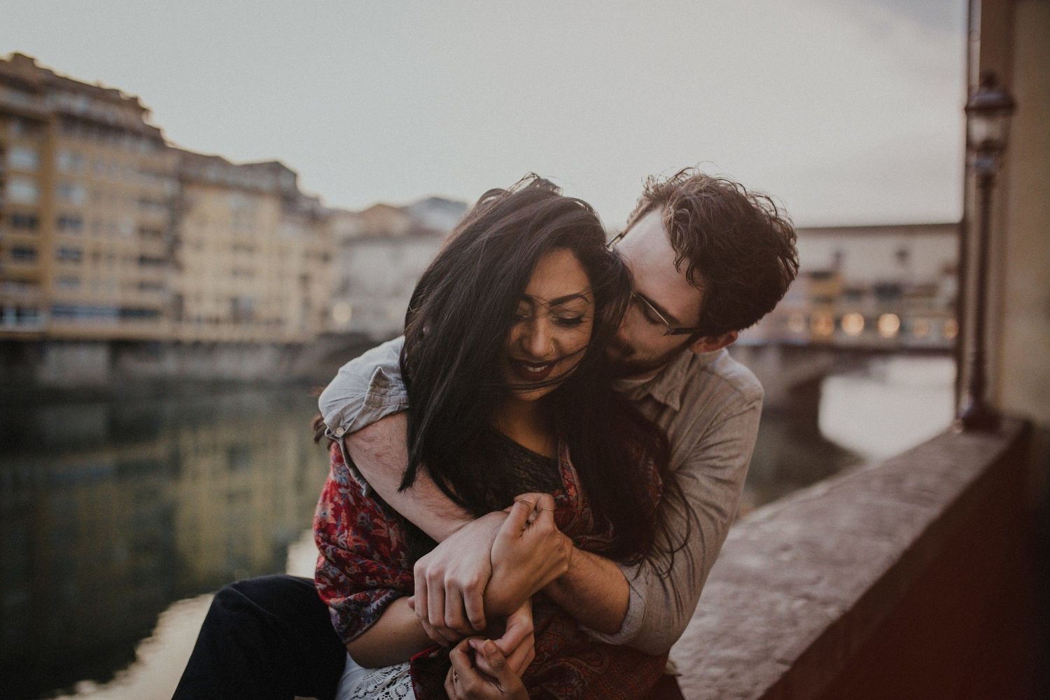 Tender embrace of couple against Florence cityscape backdrop.