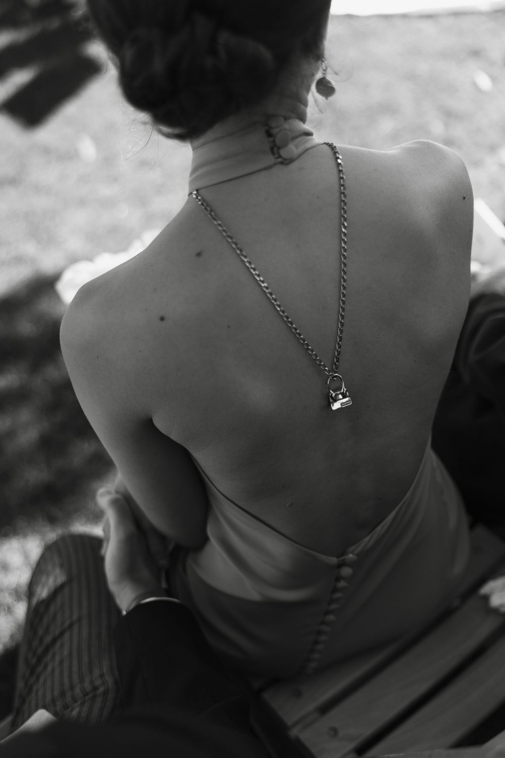 Black and white detail shot of necklaces on bare shoulders.