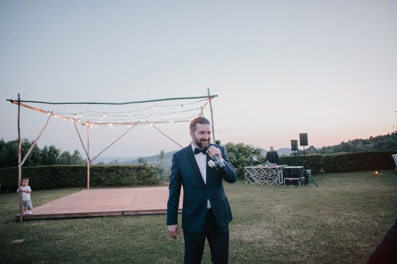 Evening outdoor event setup with string lights and a dance floor.