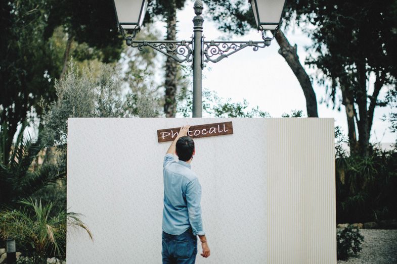 Person looking at decorative street sign mounted on white wall.