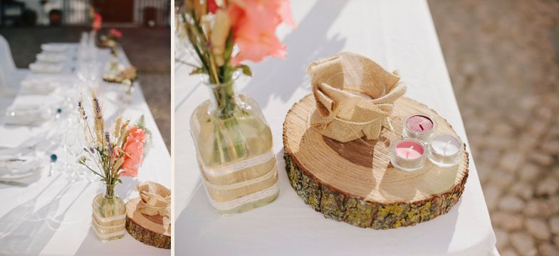 Rustic wedding table decorations featuring wooden log slices and glass vases with coral flowers.