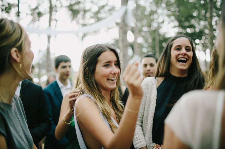 Wedding celebration with guests laughing and enjoying the outdoor forest venue.