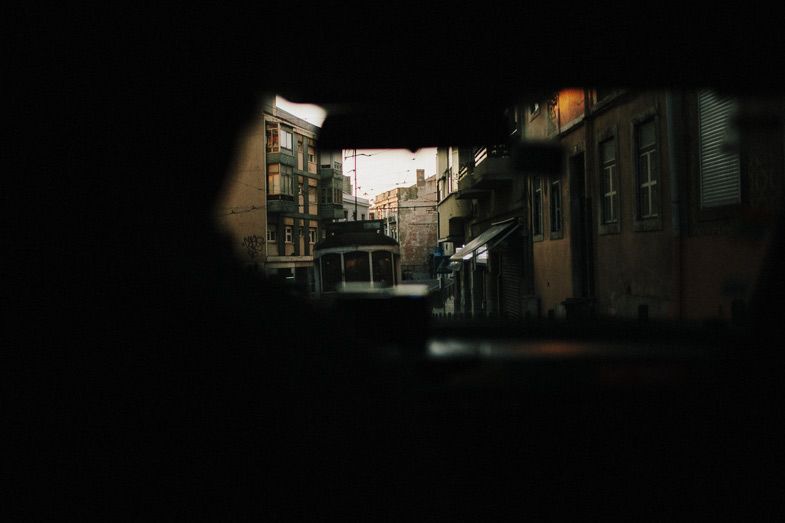 A moody dark alleyway with buildings and arches creating a dramatic urban perspective.