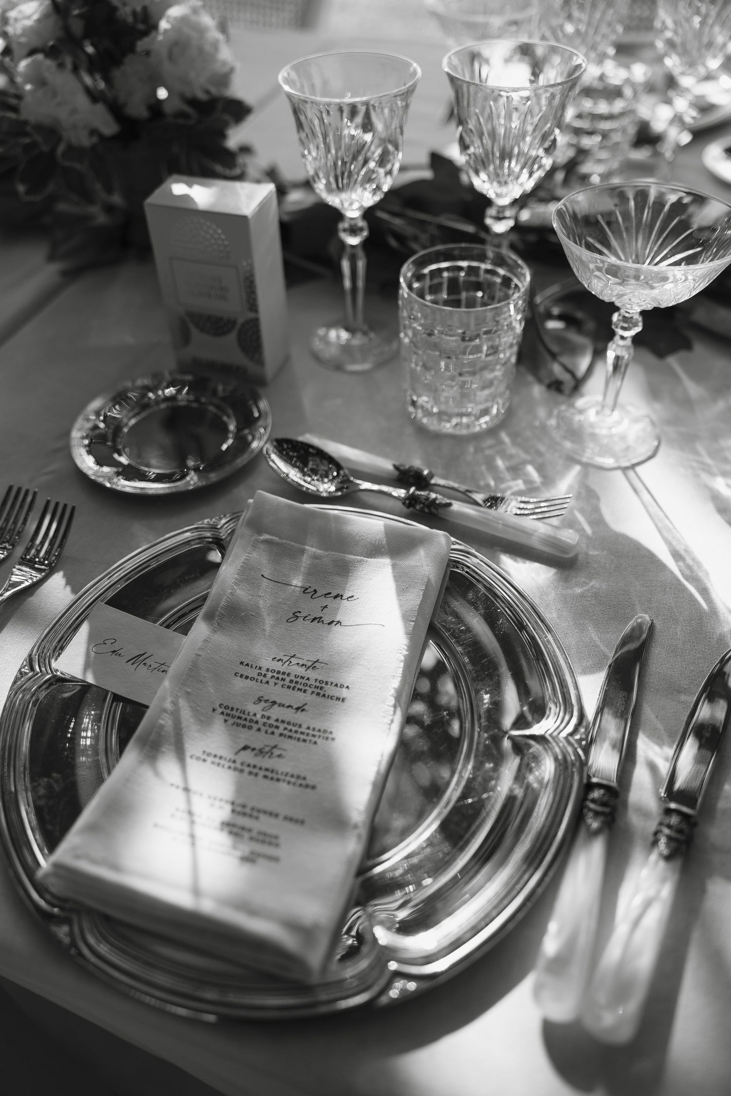 Black and white photo of luxurious wedding reception table setting with crystal stemware.