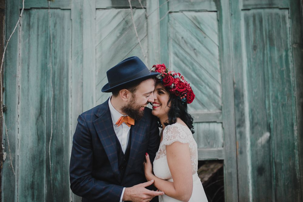 Intimate moment between newlyweds against rustic turquoise doors.