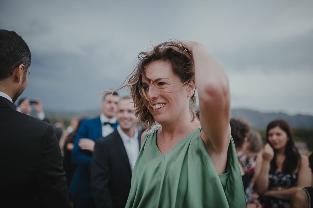 A wedding guest in green dances joyfully during the outdoor celebration.
