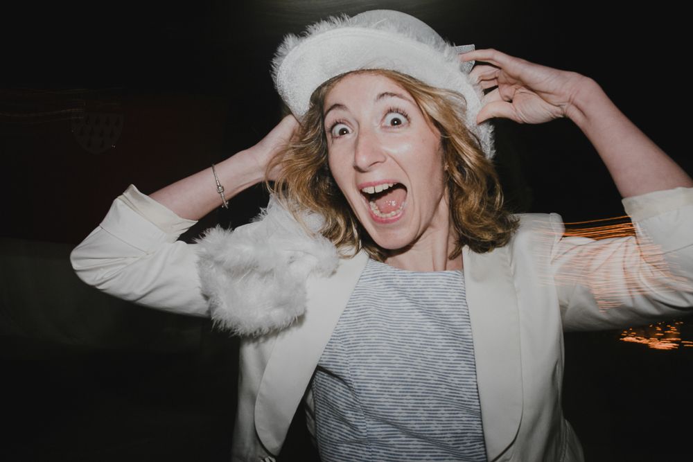 Guest in winter white attire expressing excitement at a festive celebration.