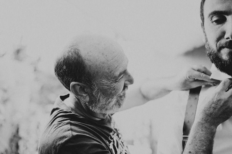 Black and white portrait showing a grooming moment between two people.