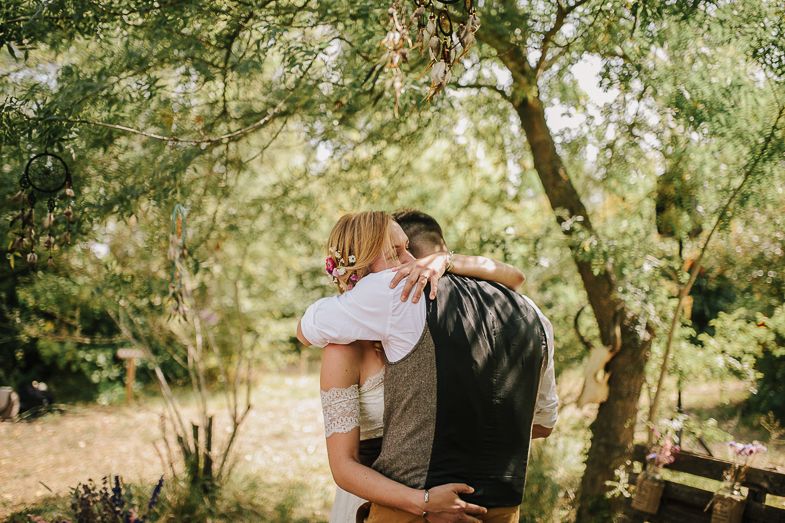 An intimate embrace captured during a woodland wedding celebration.