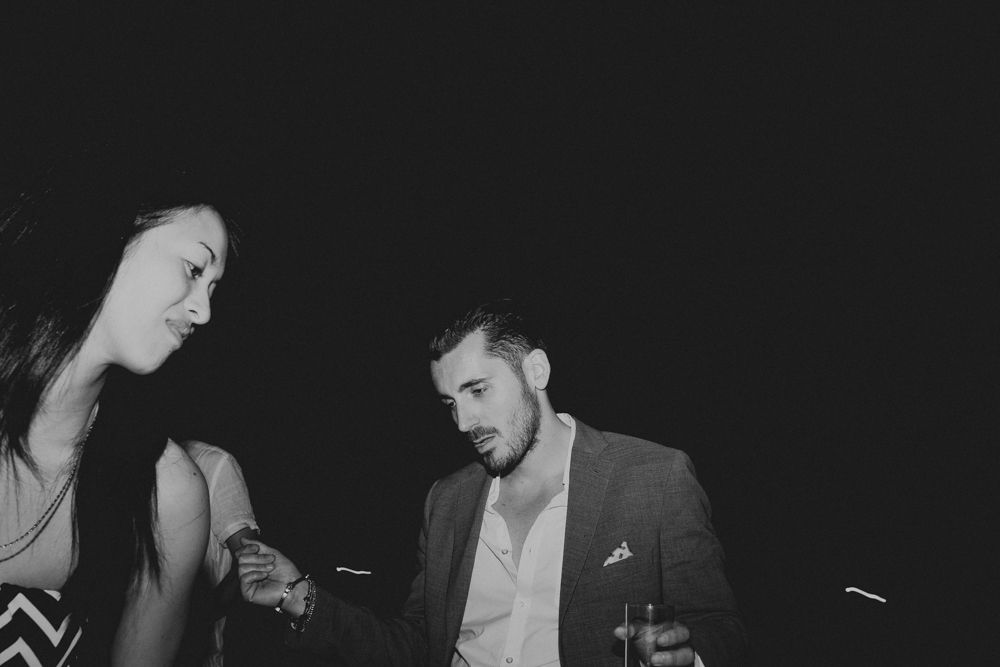 Intimate conversation between two people at a dimly lit party venue.