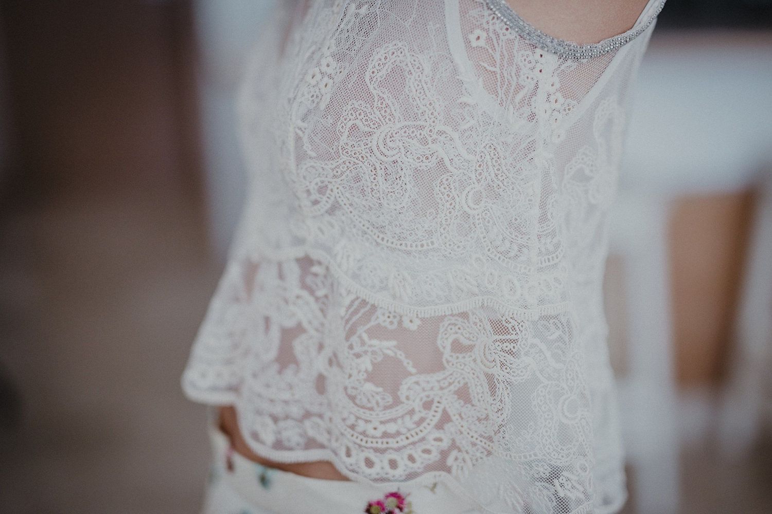 Close-up detail of intricate lace pattern on white fabric with soft lighting.