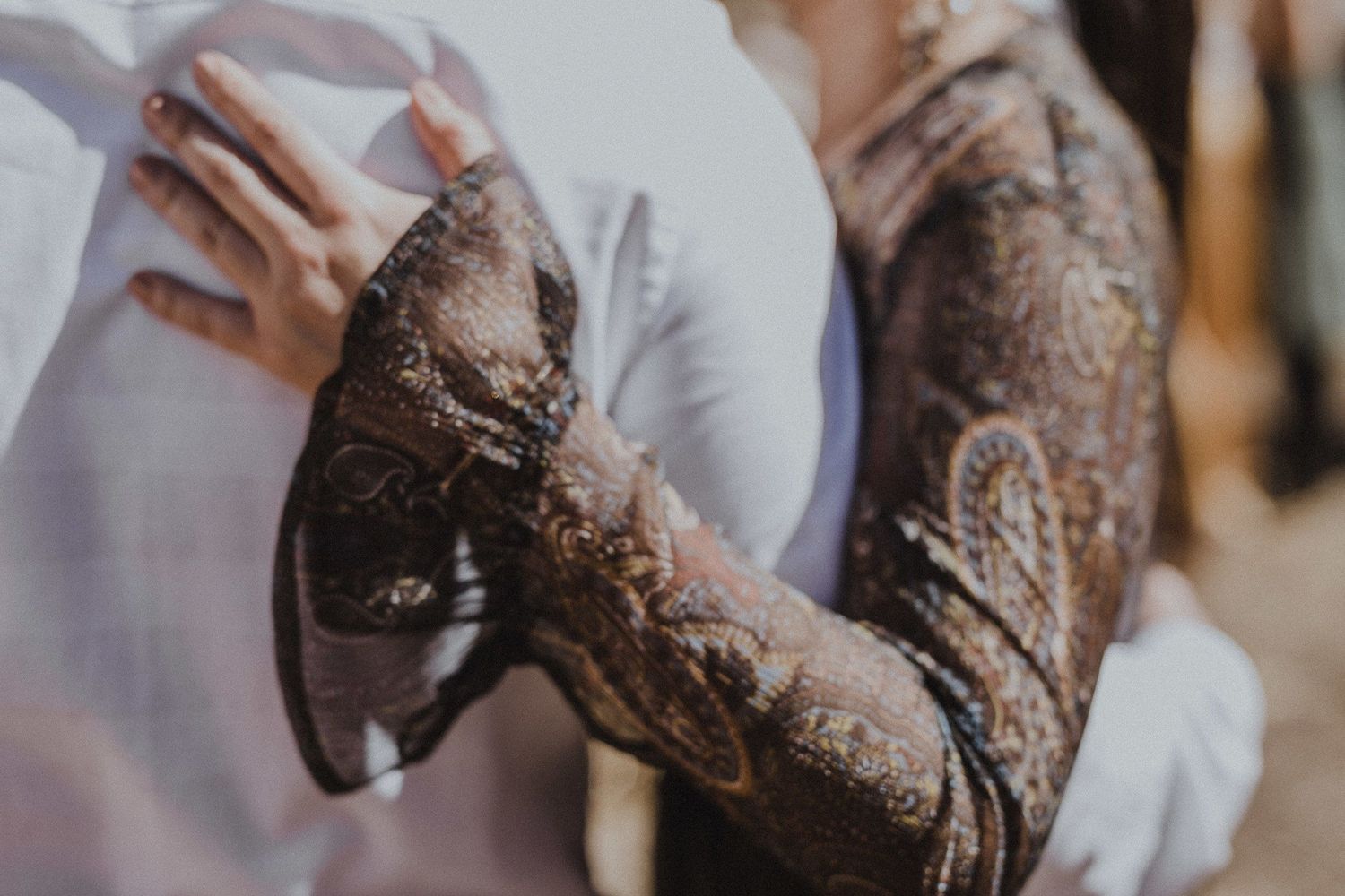 Close-up detail of an intricate lace pattern on formal attire.