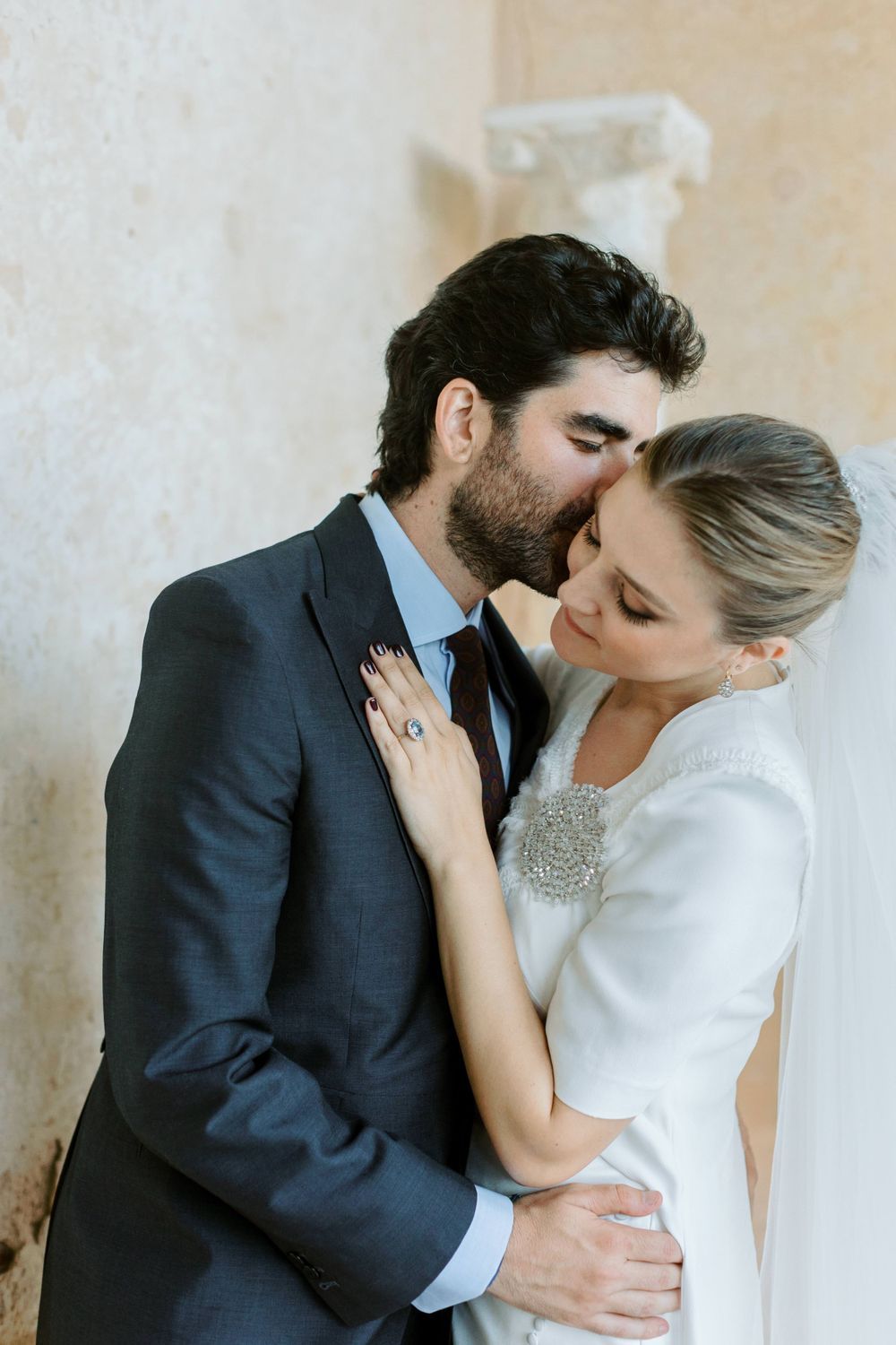 Romantic wedding couple sharing intimate kisses in a series of elegant portraits against a light background.
