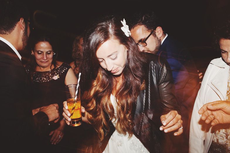 People dancing and socializing at a dimly lit nighttime party.